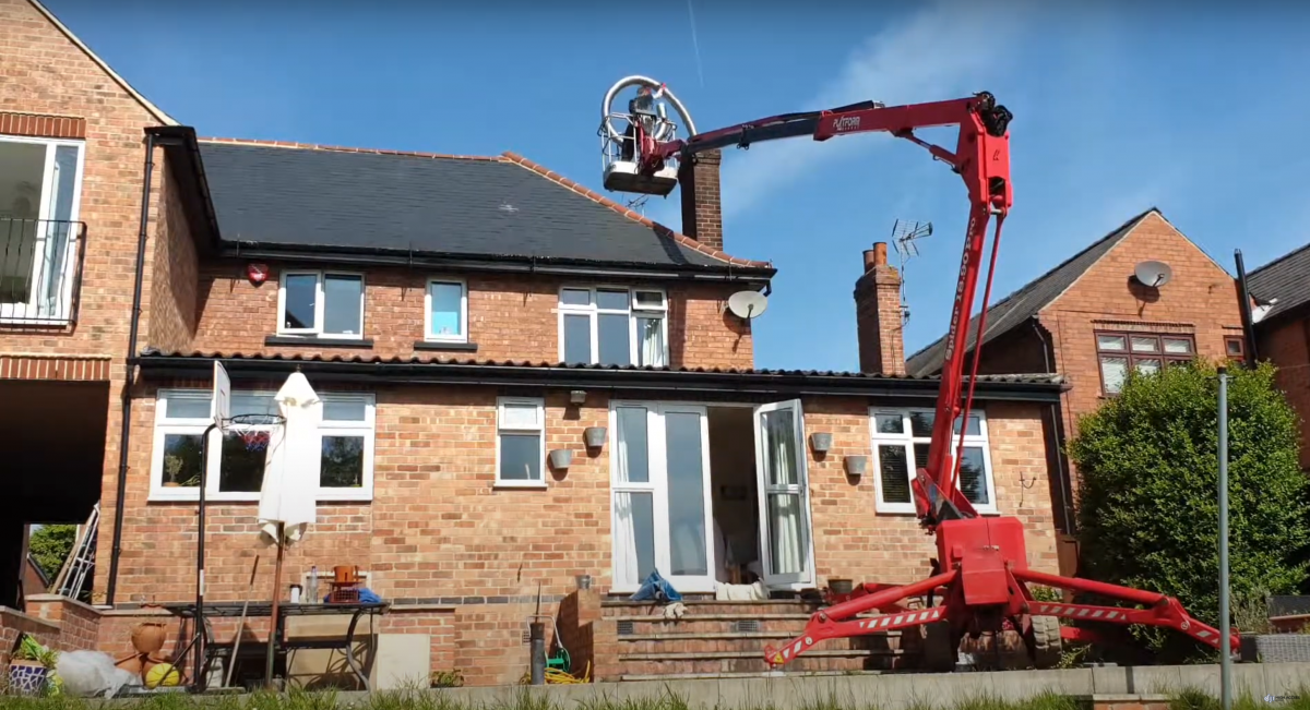 chimney liner installation from a cherrypicker Photo shows big red cherrypicker, helping to install a chimney liner on a sunny day